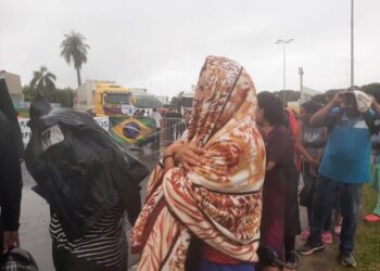 Moradores de Boa Vista enfrentam fila para receber doações de pacotes de salsicha destinados à exportação para a Venezuela